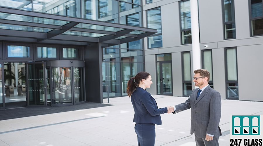 Businessman shaking hands with colleague outside office building Businessman shaking hands with colleague outside office building