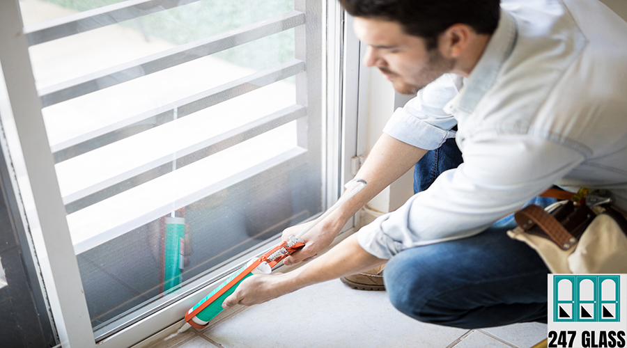 Applying some sealant on a door Closeup of a young handyman applying some sealant on a door with a sealing gun