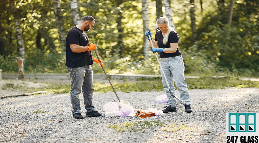 Couple collects garbage in garbage bags in park Volunteers collects rubbish. Couple in a park.