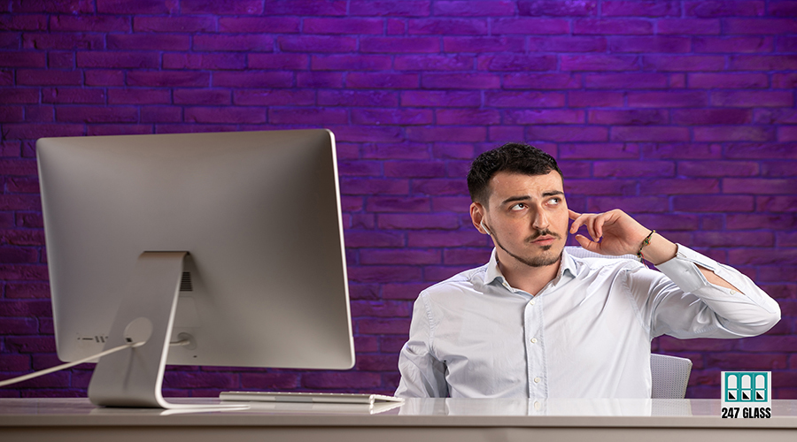 front view office worker sitting behind his working place and ta front view office worker sitting behind his working place and talking through earphones on purple background job tourism working corporate professional