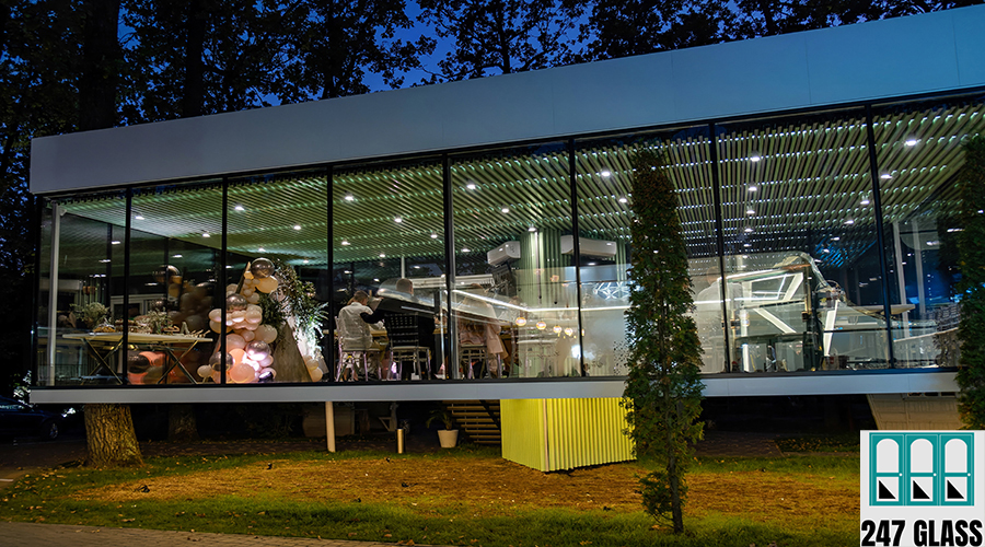 Group of people standing outside of building at night with their reflection in the windows Group of people standing outside of building at night with their reflection in the windows.