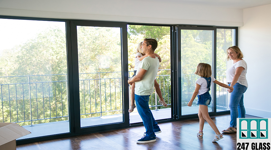 Happy father with daughter standing near open balcony Happy father with daughter standing near open balcony and smiling. Blonde mother holding girl hand and talking with her. Enjoying family watching new house or flat. Relocation and mortgage concept