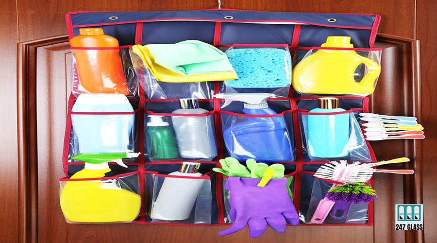 Household chemicals in holder hanging on wooden door background Household chemicals in holder hanging on wooden door background