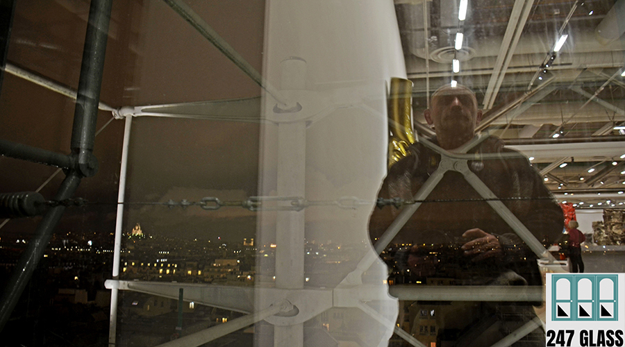 reflection-man-illuminated-building Window Installation for Retail Shops