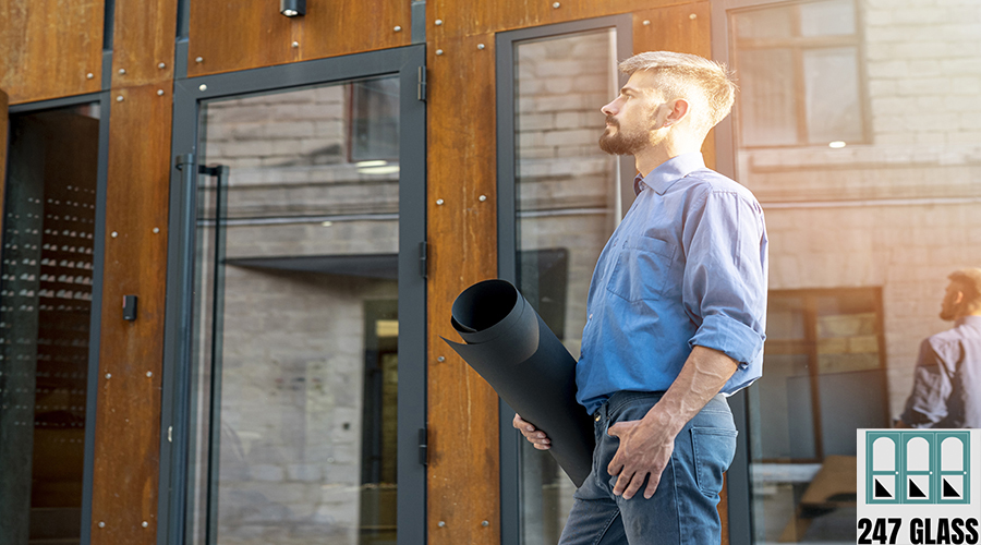 side-view-architect-holding-blueprints