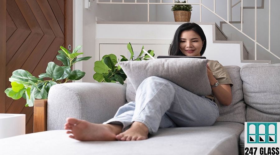 Attractive smiling young asian woman relaxing on a leather couc Attractive smiling young asian woman relaxing on a leather couch at home, working on laptop computer.