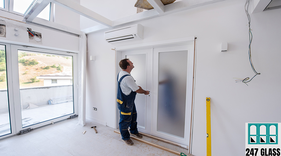 carpenters installing glass door with a wooden frame male workers carpenters installing interior glass door with a wooden frame at new luxury apartment
