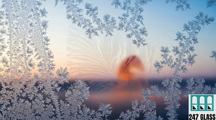Frosty Windowpane with Blurred Sunset, Delicate Ice Crystals and A close-up of a window covered in frost, with a blurred sunset visible through the ice crystals. Winter's beauty is captured in the intricate patterns.