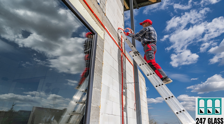 vecteezy_worker-on-ladder-installing-exterior-fixtures-on-building_61049767.webp glass replacement