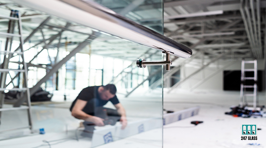 man-working-glass-wall-with-blue-sign-that-says-word-glass-it